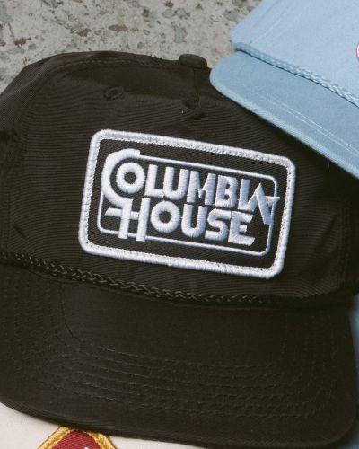 Close-up of black Columbia House patch snapback hat with embroidered white logo detail.