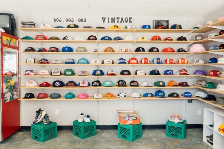 Wall display of vintage snapback hats and retro caps inside SNAG Collective retail space