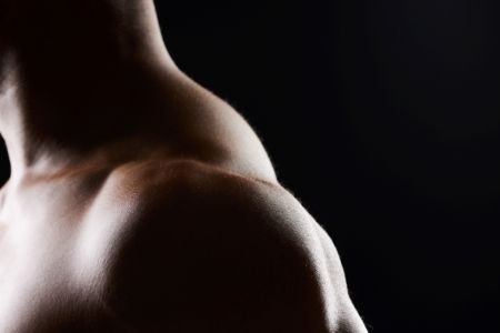 Shoulder, closeup and strong muscle of man in studio isolated on black background mockup space. Body, fitness athlete and arm of model, bodybuilder power and workout for health, wellness and exercise