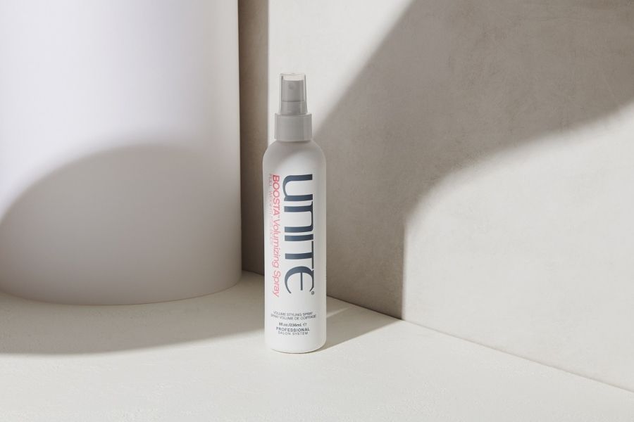 White UNITE HAIR Boosta Volumizing Spray bottle standing upright against a clean minimalist background.