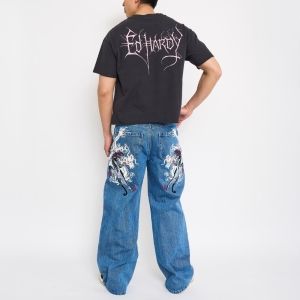 Back view of model wearing charcoal Ed Hardy cropped tee with dragon graphic jeans.
