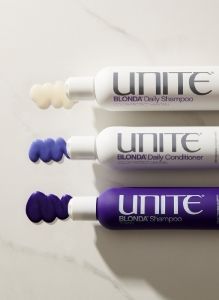 Three UNITE BLONDA hair products displayed on a marble surface with product swatches.