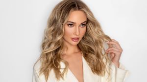 Woman with long wavy blonde hair styled with smooth volume using UNITE Hair products