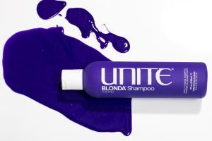 UNITE BLONDA Toning Shampoo bottle with spilled purple shampoo for blonde hair color care